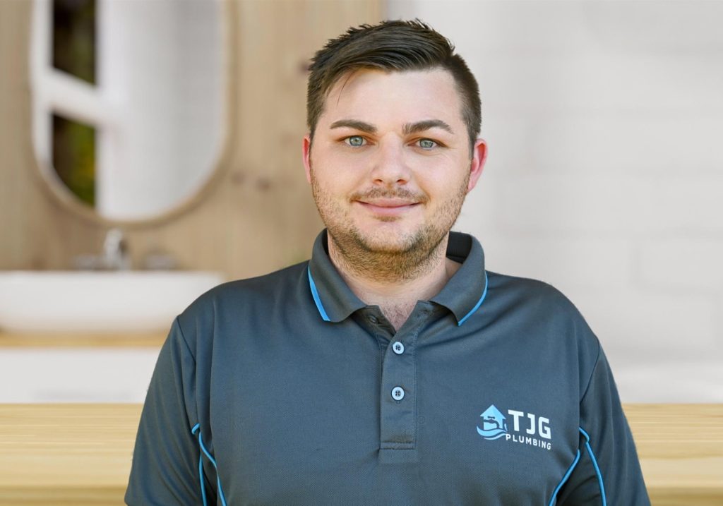 Young professional plumber in grey uniform for the About Us page